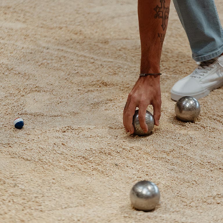 Homme ramassant ses boules de pétanque
