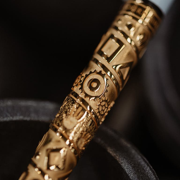 Détail du motif du stylo BIC 4 Couleurs Obut x Tournaire rose posé sur des éléments de fabrication de boules de pétanque
