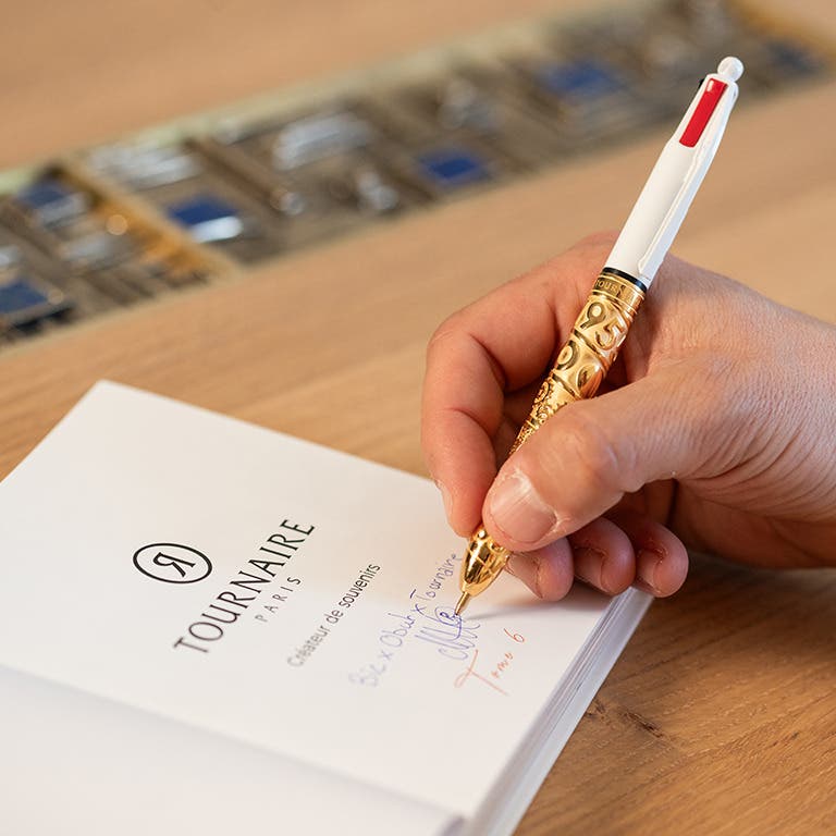 Homme écrivant avec un stylo BIC 4 Couleurs Obut x Tournaire